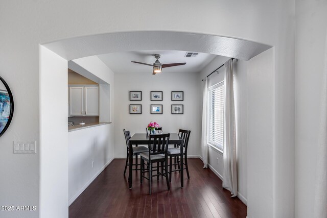 dining room featuring visible vents, dark wood finished floors, ceiling fan, and baseboards