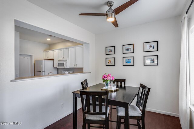 dining area featuring baseboards, a ceiling fan, dark wood-style floors, and visible vents