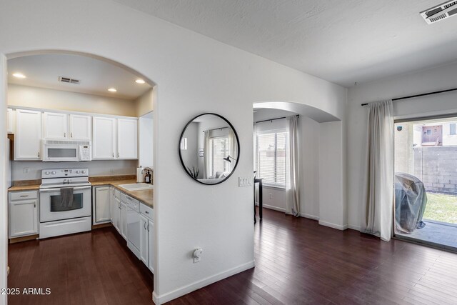 kitchen with white appliances, visible vents, plenty of natural light, and a sink