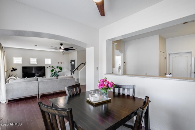 dining room featuring ceiling fan, dark wood-type flooring, stairs, and visible vents