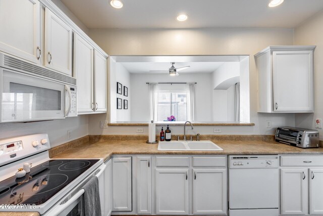 kitchen featuring white appliances, a ceiling fan, white cabinets, and a sink