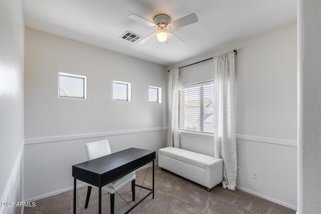 carpeted home office featuring baseboards, ceiling fan, and visible vents