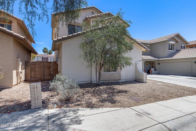 view of front of house featuring a garage, a tile roof, and stucco siding