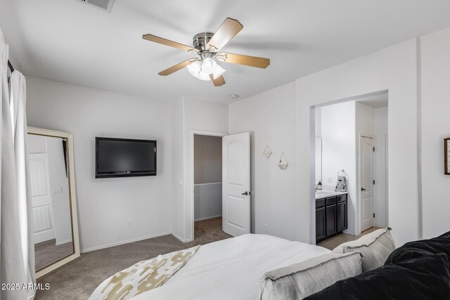 bedroom featuring baseboards, light carpet, a ceiling fan, and ensuite bath