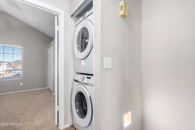 clothes washing area featuring a textured ceiling, stacked washer and dryer, and light colored carpet