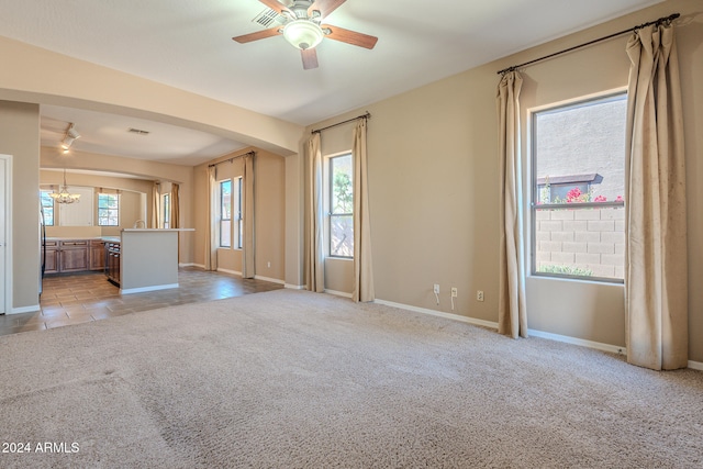 unfurnished living room featuring ceiling fan, light colored carpet, and a healthy amount of sunlight