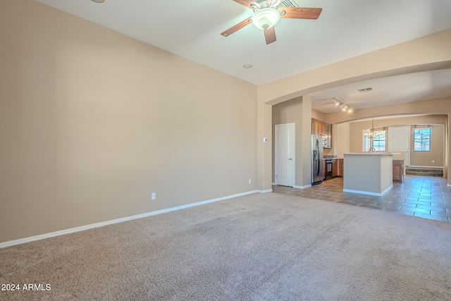 unfurnished living room with light colored carpet, vaulted ceiling, and ceiling fan