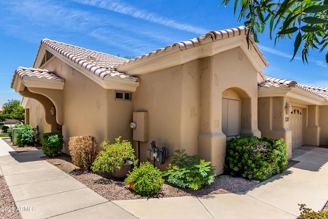 5830 E Mckellips Rd Unit 120, Mesa, AZ 85215 - view of side of property with a garage, a tiled roof, and stucco siding