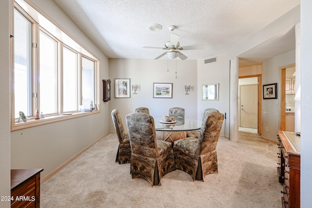 carpeted dining area with ceiling fan and a textured ceiling