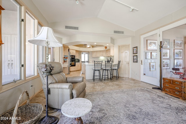 tiled living room featuring ceiling fan and lofted ceiling