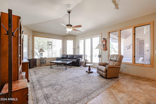 living room featuring a wealth of natural light, light tile patterned floors, ceiling fan, and lofted ceiling