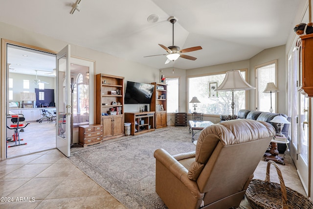 tiled living room with french doors, ceiling fan, and lofted ceiling