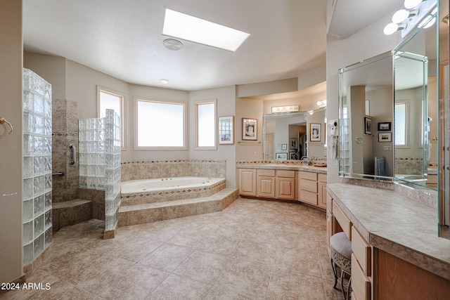 bathroom featuring tile patterned floors, a skylight, vanity, and independent shower and bath