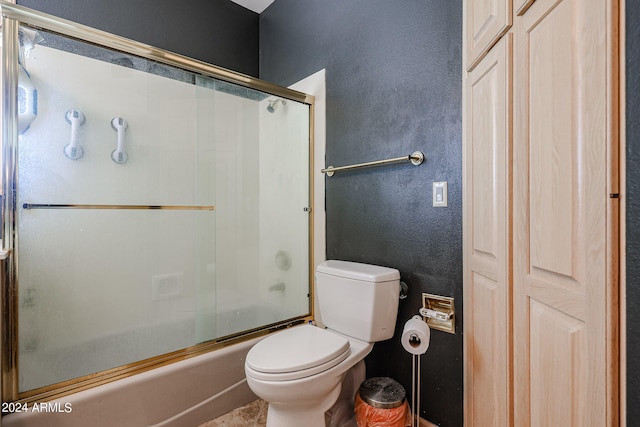 bathroom with bath / shower combo with glass door and toilet