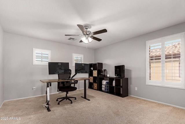 carpeted home office featuring ceiling fan