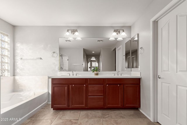 bathroom featuring tile patterned floors, vanity, a bathing tub, and a wealth of natural light