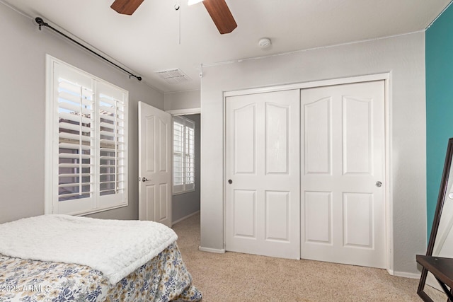 bedroom featuring light carpet, a closet, and ceiling fan