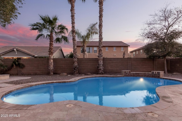 pool at dusk with a patio