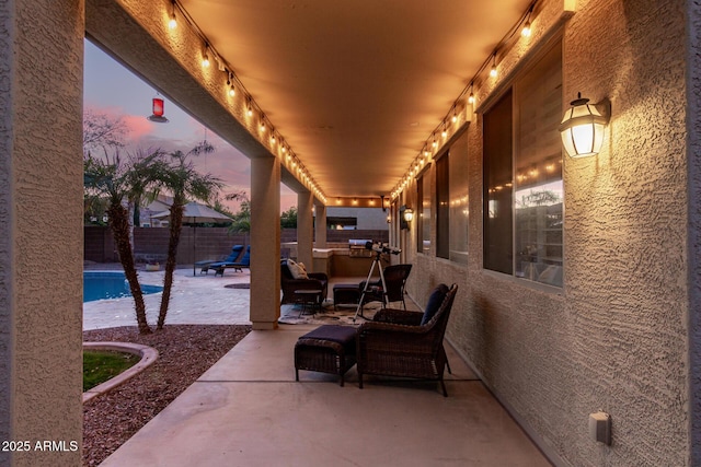 patio terrace at dusk featuring a fenced in pool and an outdoor hangout area