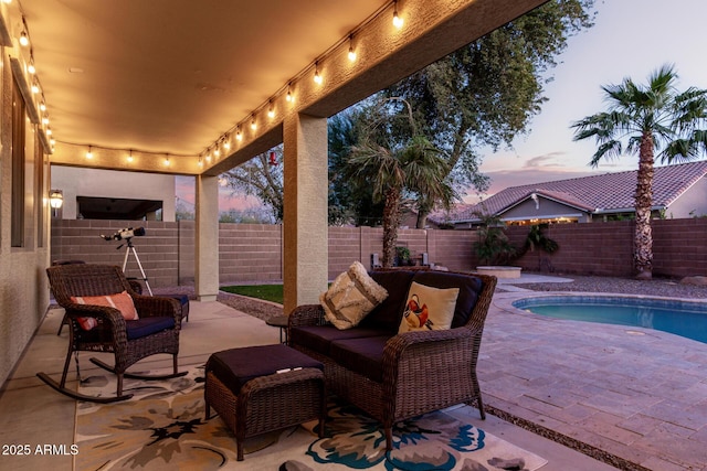 patio terrace at dusk with a fenced in pool