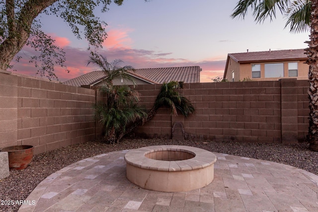 patio terrace at dusk featuring a fire pit