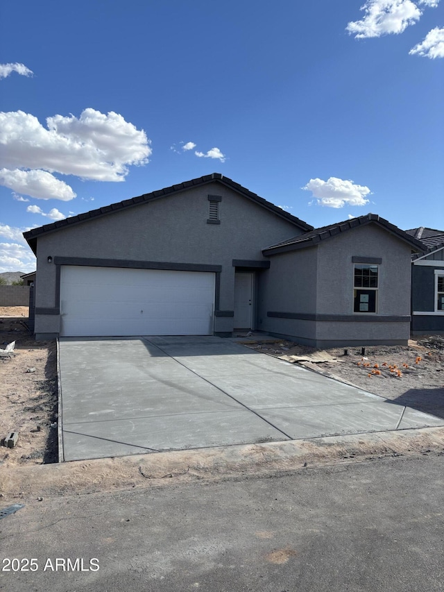 5761 E Iris Dr, Florence, AZ 85132 - single story home featuring stucco siding, an attached garage, and driveway