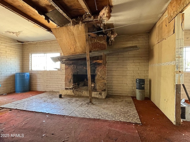 interior space featuring a stone fireplace and brick wall