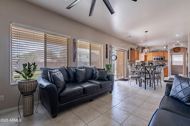 living room featuring baseboards, a ceiling fan, and light tile patterned floors