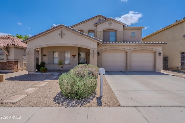mediterranean / spanish house featuring concrete driveway, a tile roof, an attached garage, and stucco siding