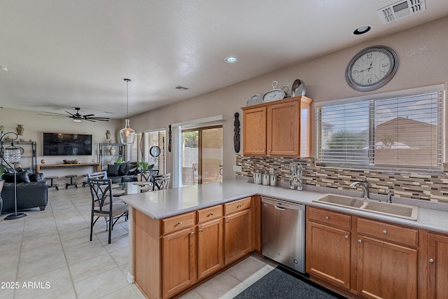 kitchen with stainless steel dishwasher, a sink, tasteful backsplash, open floor plan, and visible vents