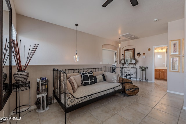 living area featuring light tile patterned flooring, visible vents, a ceiling fan, and baseboards