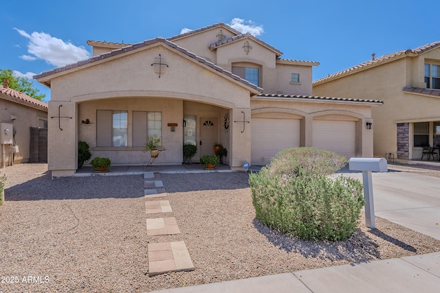 mediterranean / spanish-style house with concrete driveway, an attached garage, a tile roof, stucco siding, and covered porch