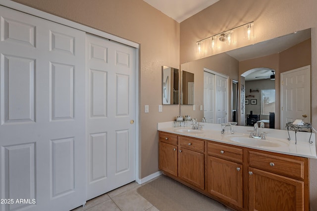 bathroom featuring tile patterned flooring, ceiling fan, a sink, and double vanity