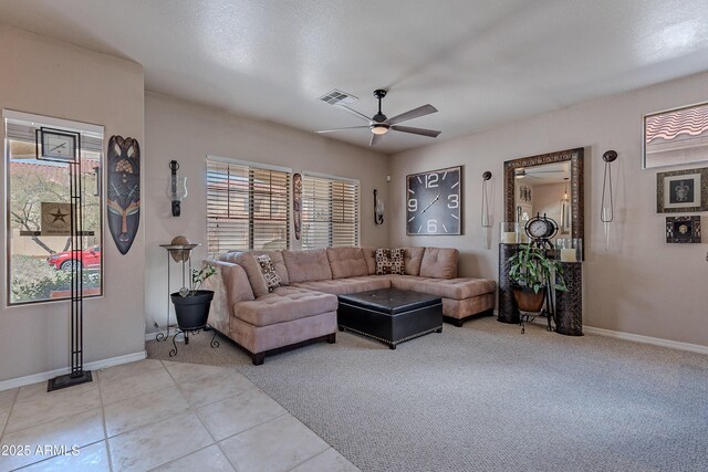 living room with visible vents, a ceiling fan, light tile patterned floors, baseboards, and light colored carpet