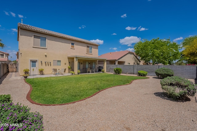 rear view of house with a patio area, a lawn, a fenced backyard, and stucco siding