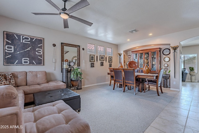 living area featuring recessed lighting, visible vents, a ceiling fan, arched walkways, and baseboards