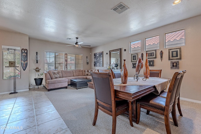 dining area with visible vents, light tile patterned flooring, baseboards, a textured ceiling, and ceiling fan