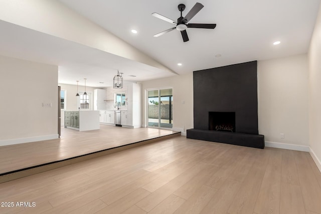 17040 N 39th Ave, Glendale, AZ 85308 - unfurnished living room featuring light wood-type flooring, ceiling fan, a fireplace, baseboards, and lofted ceiling