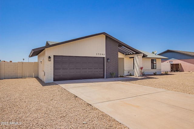 17040 N 39th Ave, Glendale, AZ 85308 - view of front facade with brick siding, a garage, fence, and concrete driveway