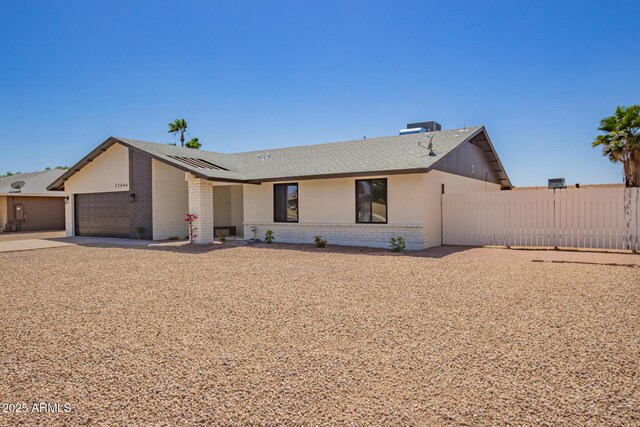 17040 N 39th Ave, Glendale, AZ 85308 - view of front of property with brick siding, solar panels, fence, a garage, and driveway