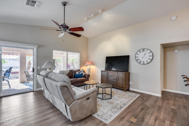 living area with wood finished floors, ceiling fan, rail lighting, lofted ceiling, and visible vents