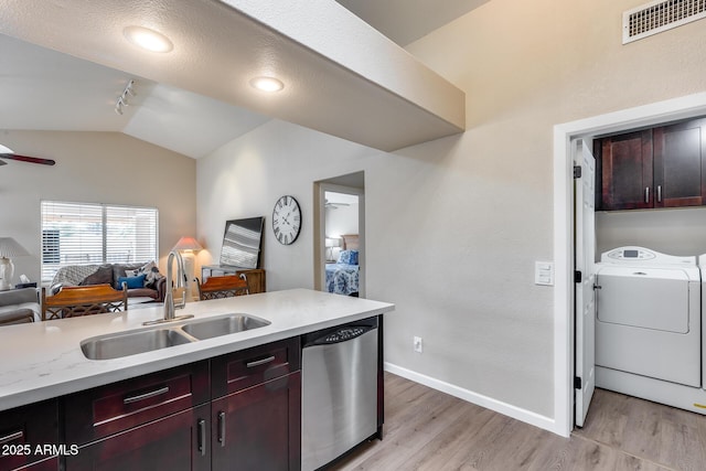 kitchen featuring stainless steel dishwasher, a sink, open floor plan, visible vents, and light wood-style floors