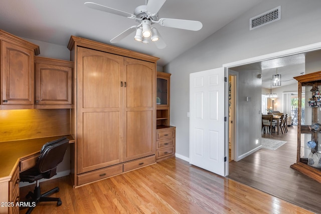 unfurnished office featuring vaulted ceiling, ceiling fan, light wood finished floors, baseboards, and visible vents
