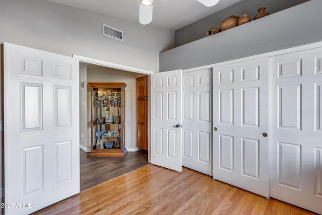 unfurnished bedroom with baseboards, light wood-style floors, visible vents, and a closet