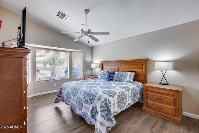 bedroom with vaulted ceiling, a ceiling fan, wood finished floors, baseboards, and visible vents
