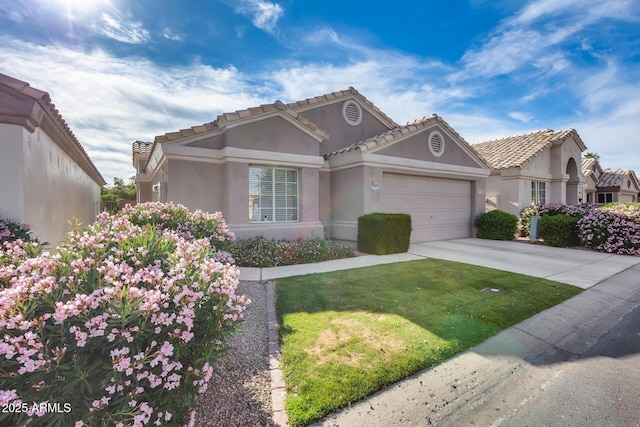 view of front of home with a tile roof, concrete driveway, an attached garage, a front yard, and stucco siding