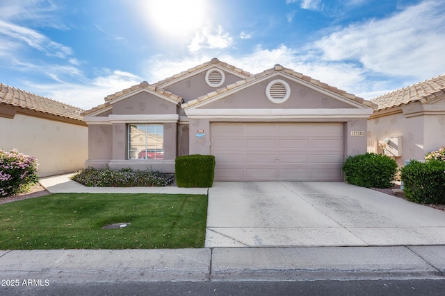 view of front of property featuring a tiled roof, concrete driveway, an attached garage, a front yard, and stucco siding