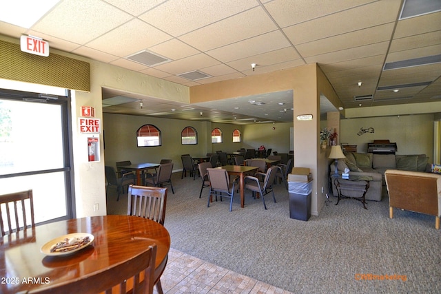 carpeted dining space featuring a paneled ceiling, visible vents, and tile patterned flooring