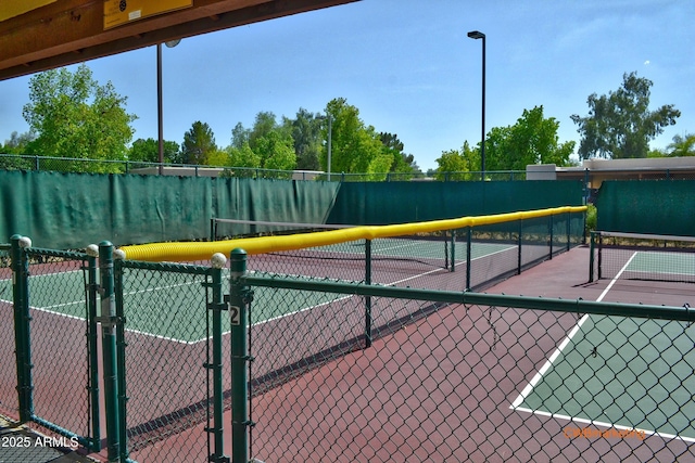 view of sport court featuring a gate and fence