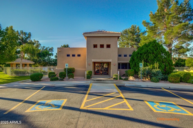 view of property featuring fence and uncovered parking